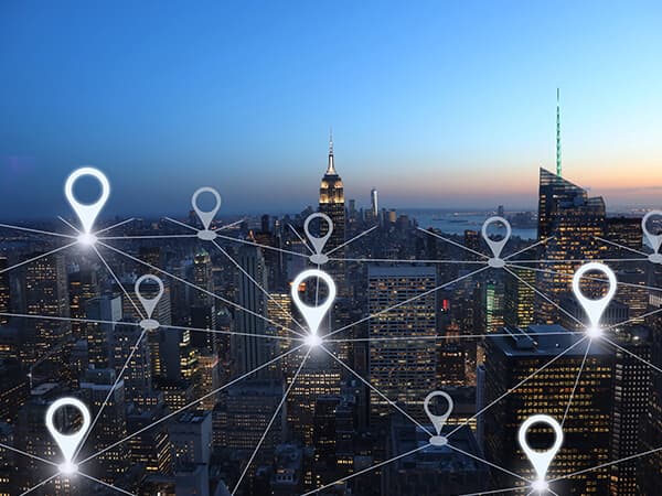 Business Multi Site Enterprise Feature 600x400 City skyline view with multiple location marker pins connected above the city