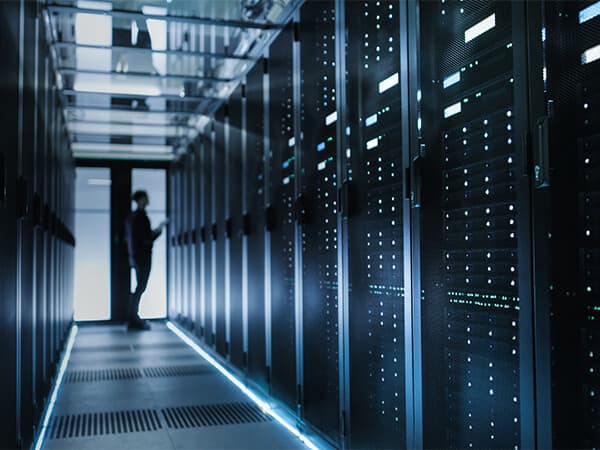 Wholesale Data Center Providers Feature Tile 600x450 Data center technician looking at rack in a data center